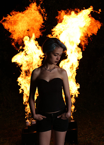 Schönes Mädchen mit Flammeneffekt im Hintergrund